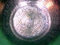 A pin-tumbler pin that has been picked using very little tension and picking force.